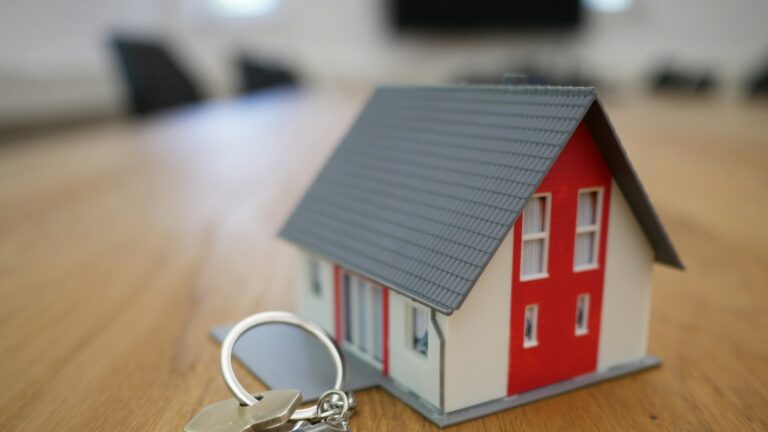 Assurance prêt immobilier : convention AERAS et droit à l’oubli Maquette de maison posée sur un bureau à côté de documents de prêt