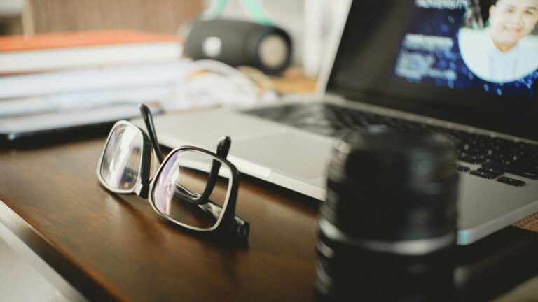 Mutuelle optique : lunettes, lentilles, panier 100 % Santé Lunettes de vue à monture noire posées sur une table en bois